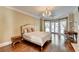 Spacious main bedroom with hardwood floors, chandelier, fireplace, and french doors at 7080 Greatwood Trl, Alpharetta, GA 30005