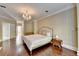 Spacious main bedroom with hardwood floors, chandelier, fireplace, and french doors at 7080 Greatwood Trl, Alpharetta, GA 30005