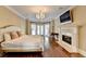 Spacious main bedroom with hardwood floors, chandelier, fireplace, and french doors at 7080 Greatwood Trl, Alpharetta, GA 30005