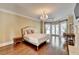 Spacious main bedroom with hardwood floors, chandelier, fireplace, and french doors at 7080 Greatwood Trl, Alpharetta, GA 30005