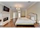 Spacious main bedroom with hardwood floors, chandelier, fireplace, and french doors at 7080 Greatwood Trl, Alpharetta, GA 30005