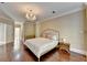 Spacious main bedroom with hardwood floors, chandelier, fireplace, and french doors at 7080 Greatwood Trl, Alpharetta, GA 30005