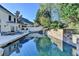 Backyard pool featuring a stone waterfall, mature landscaping, and a spacious patio at 7080 Greatwood Trl, Alpharetta, GA 30005