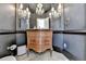 Elegant powder room with dark walls, decorative mirror, sconces, and beautiful carved vanity at 7080 Greatwood Trl, Alpharetta, GA 30005