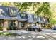 Charming townhomes featuring a manicured lawn, individual front doors, and black vehicles parked on blacktop at 102 Adrian Nw Pl, Atlanta, GA 30327
