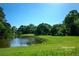 Scenic view of the golf course with lush greenery and a tranquil pond under a clear blue sky at 102 Adrian Nw Pl, Atlanta, GA 30327