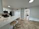 Open-concept kitchen featuring a breakfast bar, white cabinets, stainless steel appliances, and stylish flooring at 102 Adrian Nw Pl, Atlanta, GA 30327