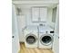 Bright laundry room featuring a full-size washer and dryer with modern appliances and storage cabinets at 102 Adrian Nw Pl, Atlanta, GA 30327
