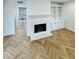 Bright living room with a fireplace and stunning herringbone floors throughout the living space at 102 Adrian Nw Pl, Atlanta, GA 30327