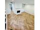 Bright living room with a fireplace and stunning herringbone floors throughout the living space at 102 Adrian Nw Pl, Atlanta, GA 30327