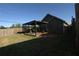 A backyard showcasing an outdoor structure with a wooden deck and partial fencing at 2362 Glebe Ct, Hampton, GA 30228