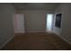 A cozy bedroom featuring neutral walls and carpet, with multiple entryways for convenience at 2362 Glebe Ct, Hampton, GA 30228