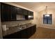 Eat-in kitchen featuring stainless steel sink, dark cabinets, countertops, and hardwood floors at 2362 Glebe Ct, Hampton, GA 30228