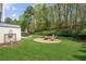Beautifully landscaped backyard with a fire pit and patio seating, perfect for outdoor entertaining at 2523 Bancroft Way, Buford, GA 30519