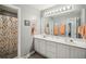Bright bathroom featuring dual vanities, a large mirror, and a shower with a colorful curtain at 2523 Bancroft Way, Buford, GA 30519