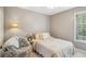 Neutral bedroom with a large window, comfortable bed, and reading nook at 2523 Bancroft Way, Buford, GA 30519