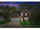 Exterior night view of brick home with manicured lawn and illuminated entrance at 2523 Bancroft Way, Buford, GA 30519