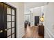 Bright foyer featuring wood floors, white wainscoting, and a view into the living area at 2523 Bancroft Way, Buford, GA 30519