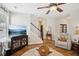 Cozy living room featuring hardwood floors, a ceiling fan, and a staircase leading to the upper level at 2523 Bancroft Way, Buford, GA 30519