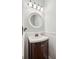 Stylish half bathroom with a dark vanity and elegant mirror at 2523 Bancroft Way, Buford, GA 30519