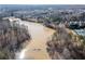 Aerial view of a residential area with a large pond surrounded by trees and homes at 333 Gardens Of Harmony Dr, Canton, GA 30115