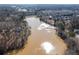 Scenic aerial view of a serene lake, reflecting sunlight, surrounded by lush trees and residential areas at 333 Gardens Of Harmony Dr, Canton, GA 30115