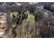 Expansive aerial view of a wooded area with a clearing, surrounded by residential houses at 333 Gardens Of Harmony Dr, Canton, GA 30115