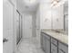 Modern bathroom with granite counters, gray cabinetry, and a glass-enclosed shower at 333 Gardens Of Harmony Dr, Canton, GA 30115