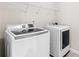 This laundry room has a modern washer, dryer, and convenient storage shelves at 333 Gardens Of Harmony Dr, Canton, GA 30115