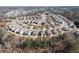 A high angle view of the community reveals neatly arranged homes, some with colorful facades, amongst bare trees at 333 Gardens Of Harmony Dr, Canton, GA 30115