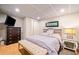 Cozy bedroom with a large bed, wood-look floors, a TV, and a comfortable bench at 3919 Evans Rd, Cumming, GA 30040