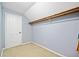 Small closet with an overhead shelf, neutral carpet, light blue walls, and a white door at 3919 Evans Rd, Cumming, GA 30040