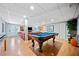 Finished basement features a pool table with an orange leather sofa by the fireplace and tv at 3919 Evans Rd, Cumming, GA 30040