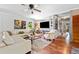 Bright living room with hardwood floors, a comfortable sofa, and built-in shelving at 3919 Evans Rd, Cumming, GA 30040