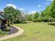 Beautiful yard with mature trees and landscaping beside a single-Gathering home with a walkway at 3919 Evans Rd, Cumming, GA 30040