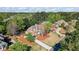 Aerial view of a brick home with a well-manicured lawn, surrounded by trees at 6690 Stillmeadow Dr, Cumming, GA 30040