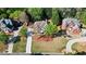 Aerial view of a manicured lawn with blossoming azaleas, trees, and a circular driveway at 6690 Stillmeadow Dr, Cumming, GA 30040