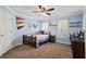 Cozy carpeted bedroom featuring a ceiling fan and natural light from the window at 6690 Stillmeadow Dr, Cumming, GA 30040