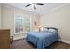 Cozy bedroom with a ceiling fan, large window, and a comfortable blue bed at 6690 Stillmeadow Dr, Cumming, GA 30040
