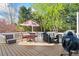 Outdoor deck showcasing dining set, grill, and Big Green Egg surrounded by lush landscaping at 6690 Stillmeadow Dr, Cumming, GA 30040