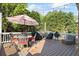 Spacious deck with dining and seating areas, multiple grills, and overhead string lights at 6690 Stillmeadow Dr, Cumming, GA 30040