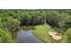 Scenic aerial view of a lush golf course with a tranquil pond surrounded by trees at 6690 Stillmeadow Dr, Cumming, GA 30040
