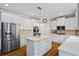 Bright kitchen features white cabinets, an island, and stainless steel appliances for a modern appeal at 6690 Stillmeadow Dr, Cumming, GA 30040