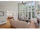 Bright, airy living room with two-story windows and open floor plan to dining and kitchen at 6690 Stillmeadow Dr, Cumming, GA 30040