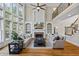 Open living room featuring a cozy fireplace, built-in shelving, and large two-story windows at 6690 Stillmeadow Dr, Cumming, GA 30040