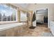 The main bathroom has a soaking tub, tiled shower, white double vanity, and tile floors at 6690 Stillmeadow Dr, Cumming, GA 30040