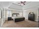 Spacious main bedroom features a tray ceiling, carpet floors, neutral paint and a ceiling fan at 6690 Stillmeadow Dr, Cumming, GA 30040