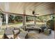 Covered patio with stone floor features seating area, ceiling fan, and view of the backyard at 6690 Stillmeadow Dr, Cumming, GA 30040
