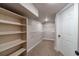 Walk-in closet features carpet flooring, and open shelves that provides ample storage space for an organized wardrobe at 255 Sageglen Rd, Lawrenceville, GA 30044