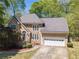 Exterior featuring a stone and stucco facade, complemented by a paved driveway leading to an attached two-car garage at 255 Sageglen Rd, Lawrenceville, GA 30044